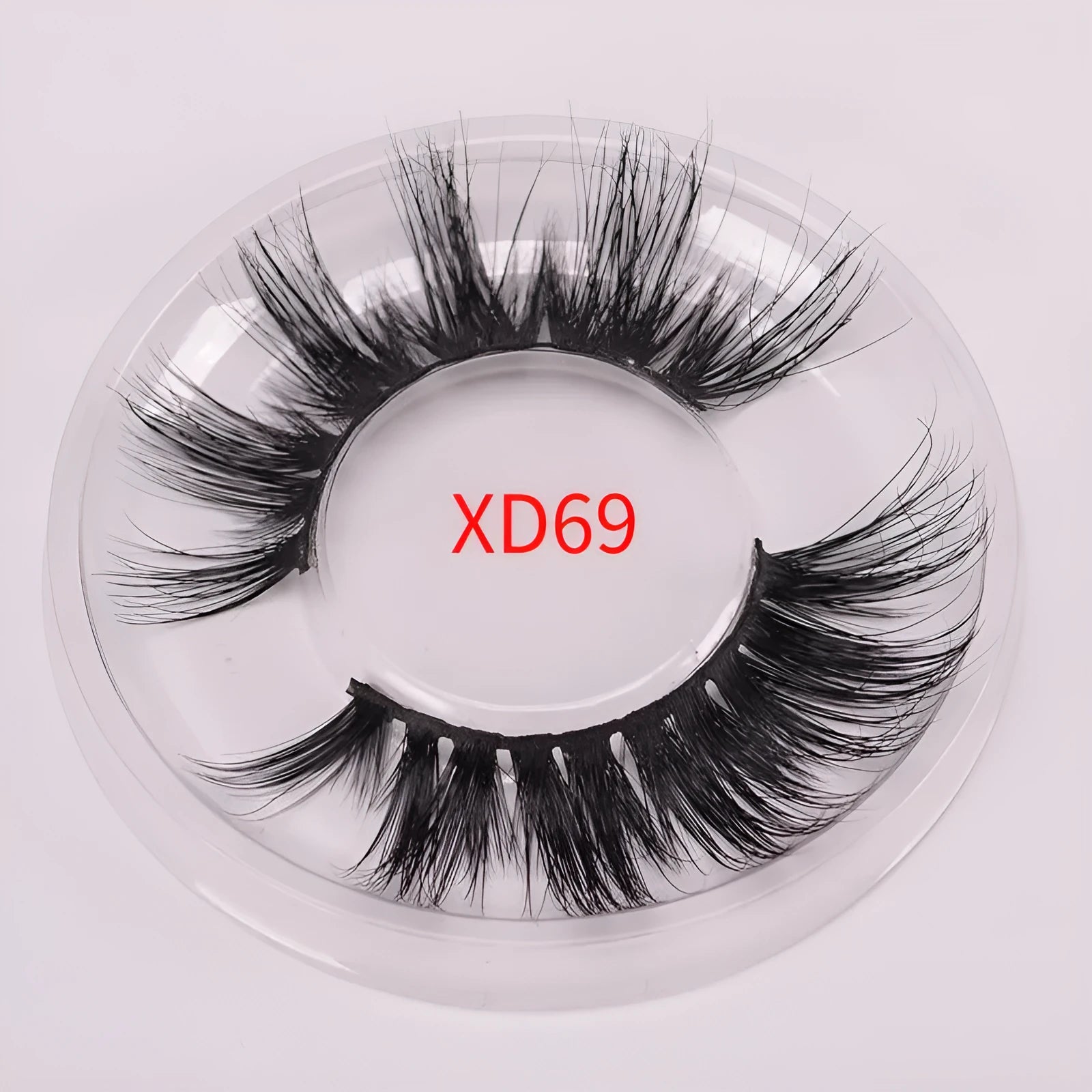 A pair of handcrafted 5D mink false eyelashes with applicator brush and storage case on a clean background.