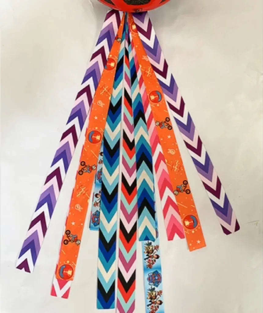 Close-up of a colourful decorative ribbon streamer attached to a child's helmet for roller skating or skiing.