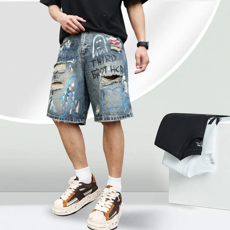 Blue ripped men's denim shorts with graffiti pattern and straight-leg cut.