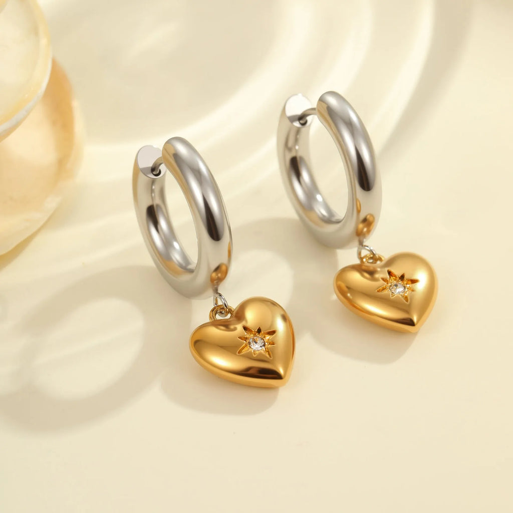 A pair of stainless steel earrings with an 18K gold colour finish, shown in a Christmas tree shape and a heart shape.