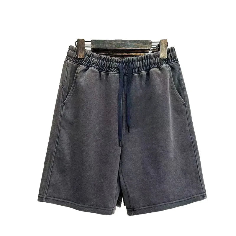 Men's charcoal black distressed denim shorts with straight leg and fifth pants length on a white background.