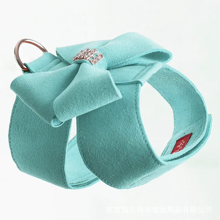 Soft pink microfiber puppy chest strap with a large white bowknot decoration laid flat.