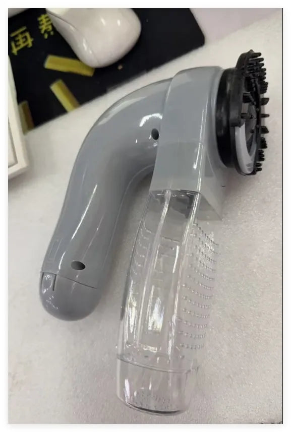 Grey handheld pet hair vacuum cleaner with soft rubber brush head for grooming dogs and cats.