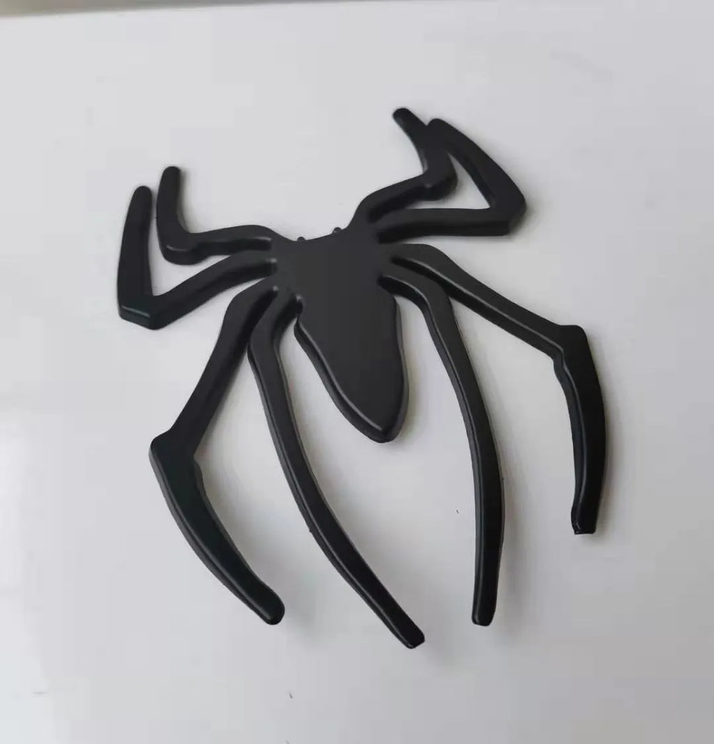 Three-dimensional metal spider sticker in gold colour, measuring 7cm by 5cm.