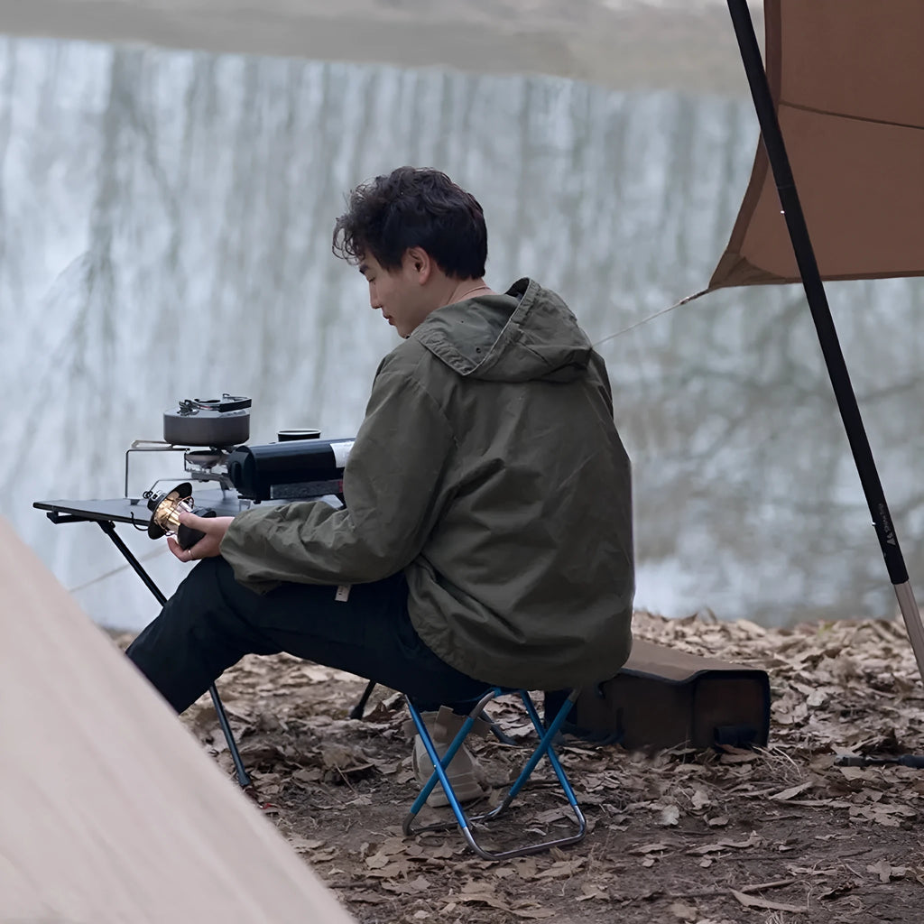 Black aluminium alloy folding camping stool shown open for use and folded flat for storage.