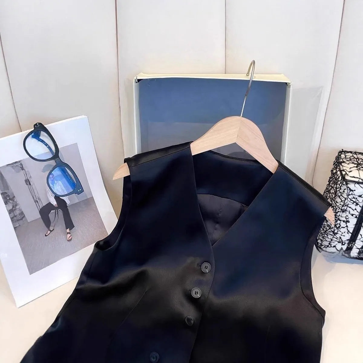 Black satin sleeveless loose-fit vest for women on a hanger