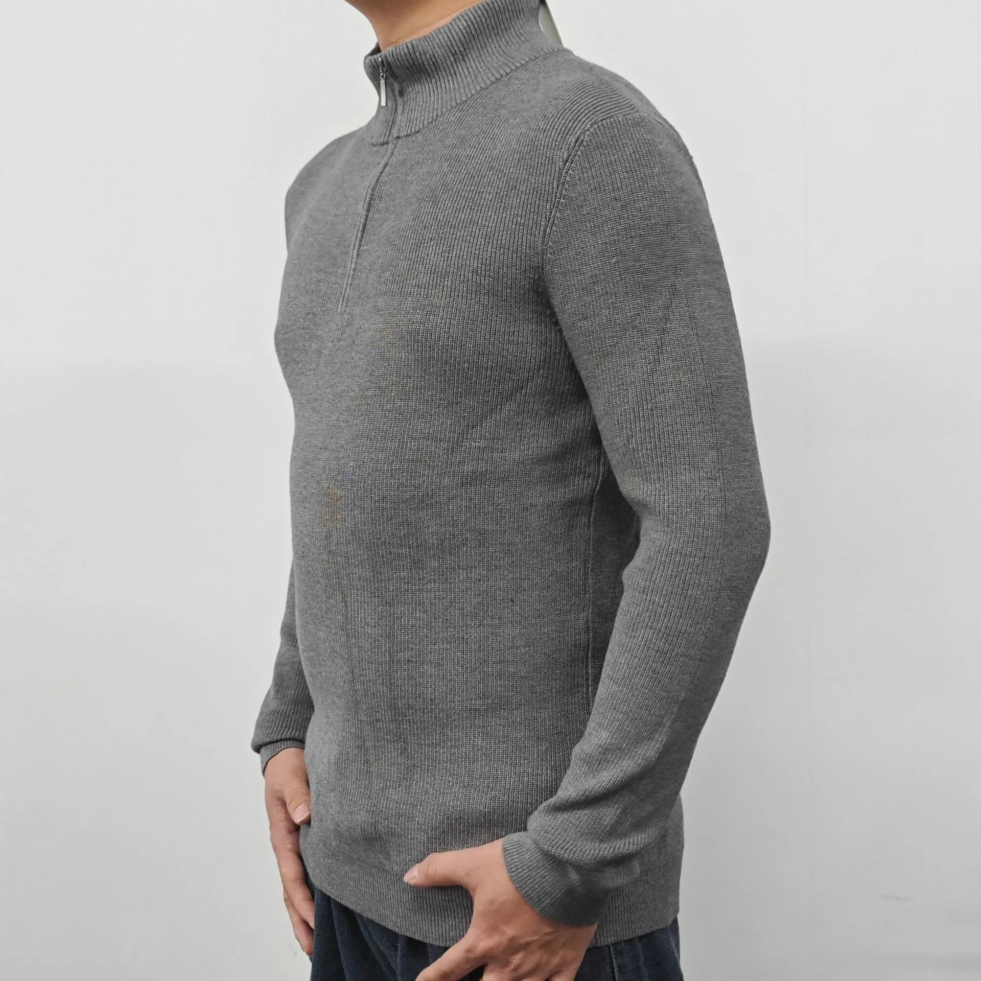 Man wearing a grey half-turtleneck zipper sweater, a cotton blend pullover for casual wear.