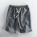 Man wearing striped light blue cotton casual shorts with a mid waist and loose straight fit.