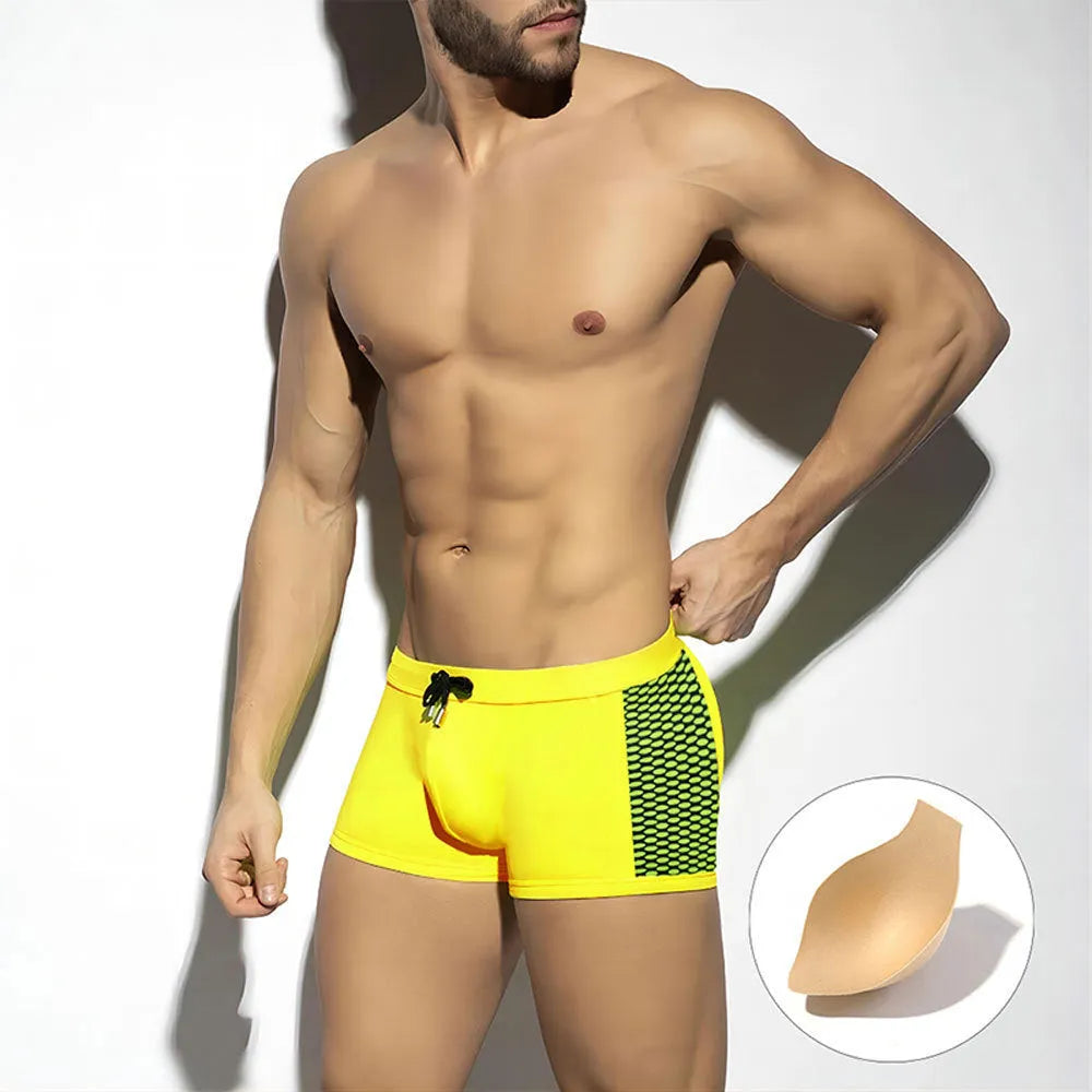 Men's black swimming boxers with white polka dot print and ribbon trim, laid flat.