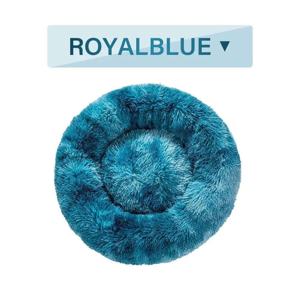 Fluffy long plush donut-shaped pet bed for dogs and cats on a wooden floor.