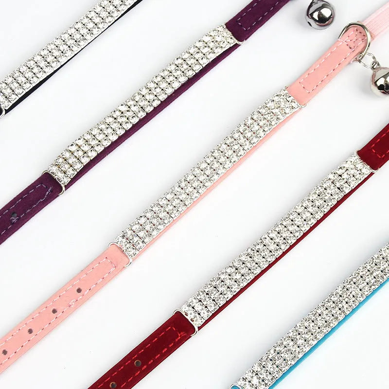 Velvet suede cat collar with rhinestone decoration in various colours on a white background.