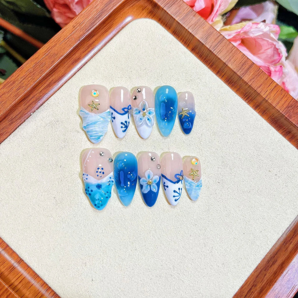 Set of blue hand-painted false nails with carved texture and a transparent summer ice aesthetic.