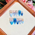 Set of blue hand-painted false nails with carved texture and a transparent summer ice aesthetic.