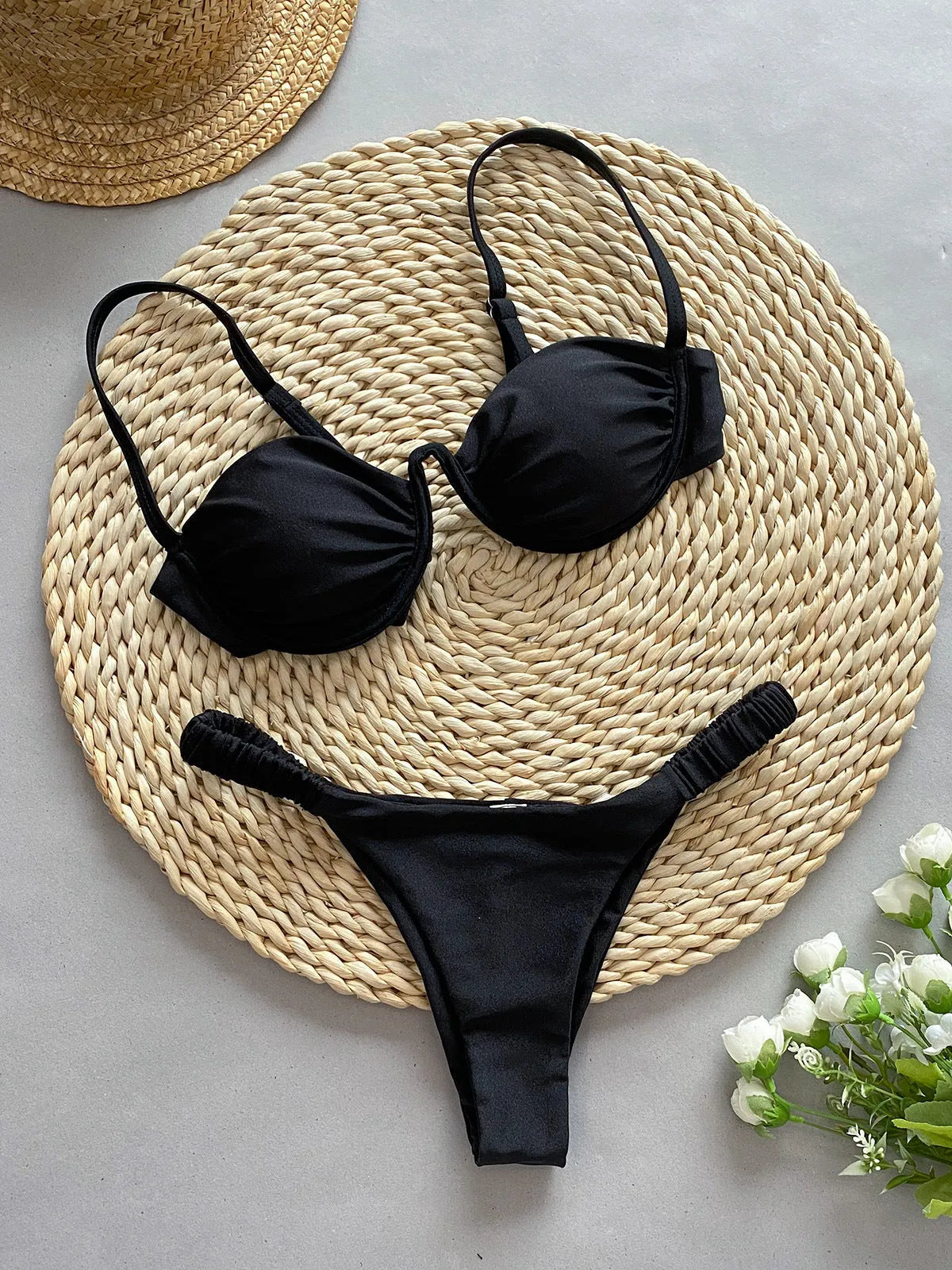 Women's black underwire bikini swimsuit on a mannequin, showing brief style and supportive fit.