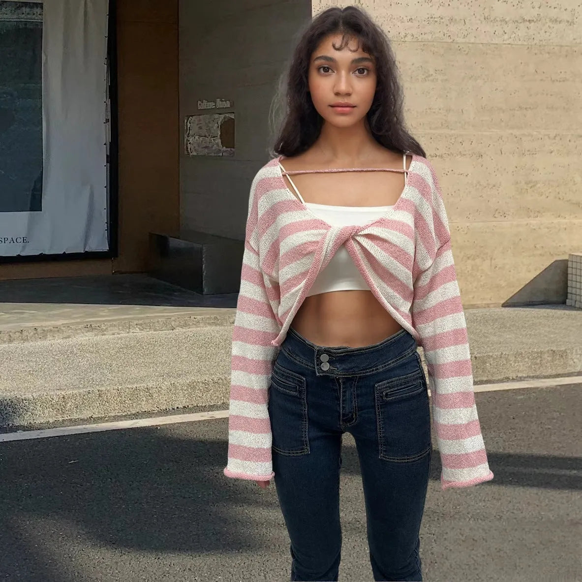 Striped long-sleeved cotton sweater with an exposed navel design on a model