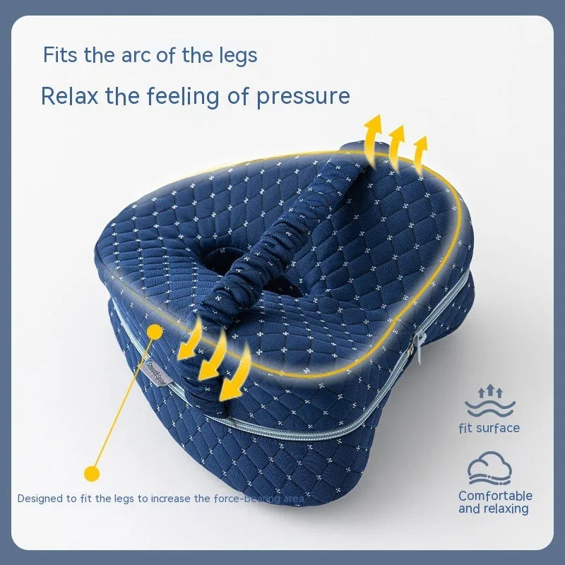 Heart-shaped dark blue memory foam leg pillow for adults on a bed