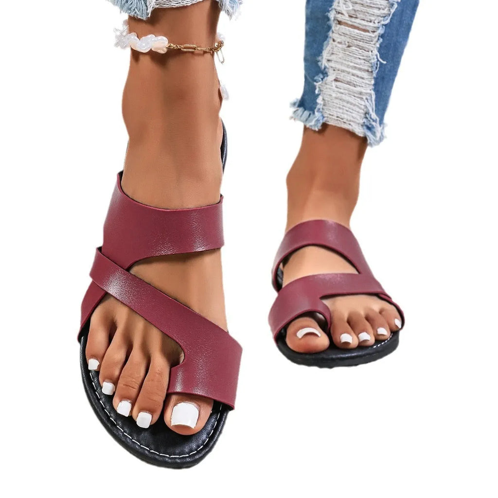 Round head casual beach slippers with a one-line design and hollow-out rubber soles.
