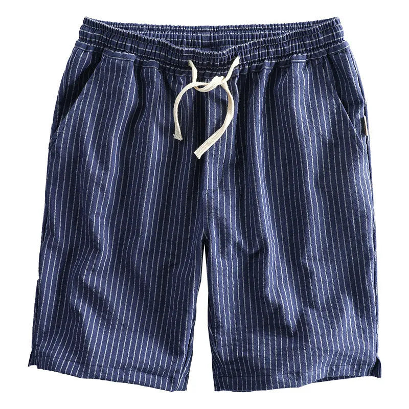 Man wearing striped light blue cotton casual shorts with a mid waist and loose straight fit.