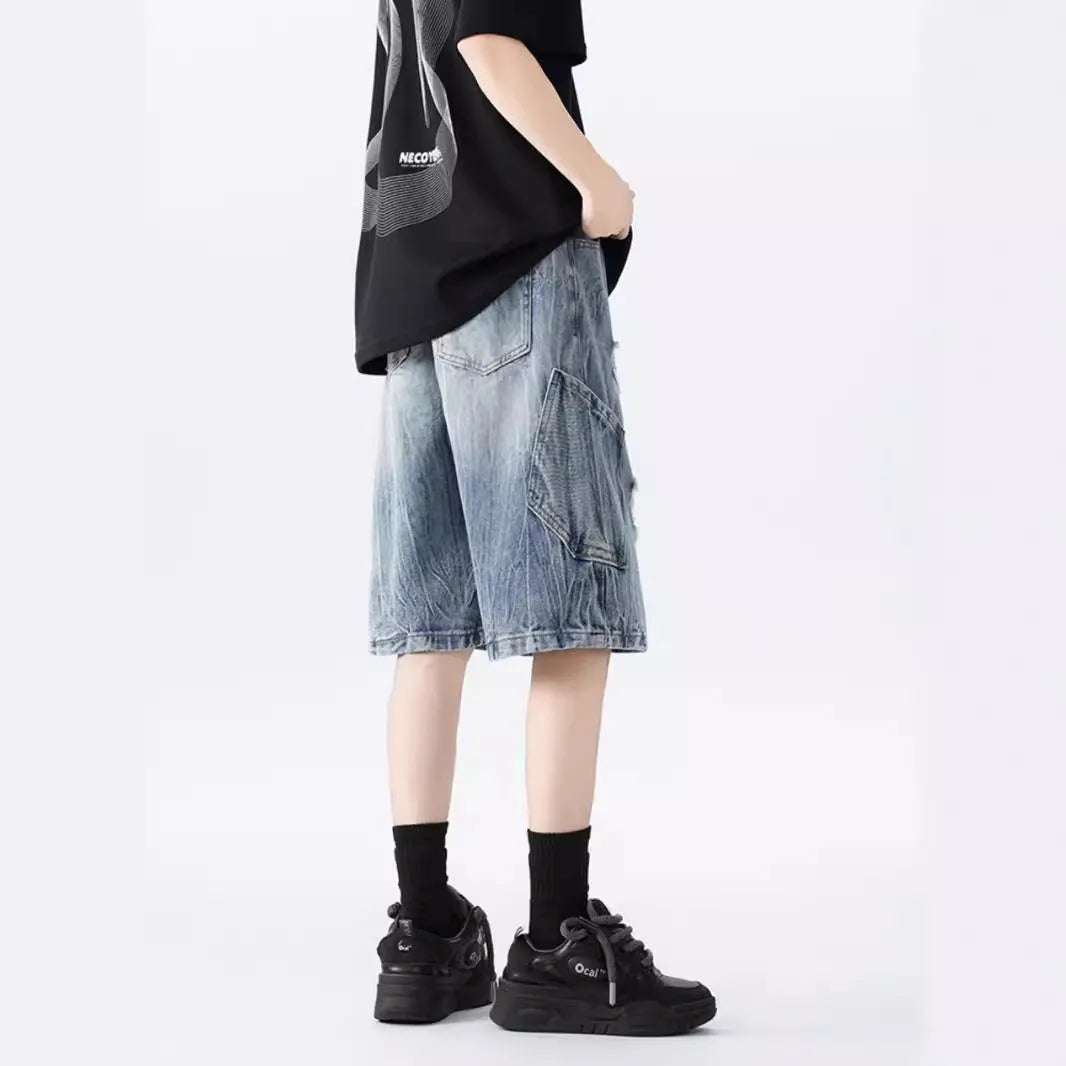 Washed black denim shorts with ripped details and loose retro fit showing front view