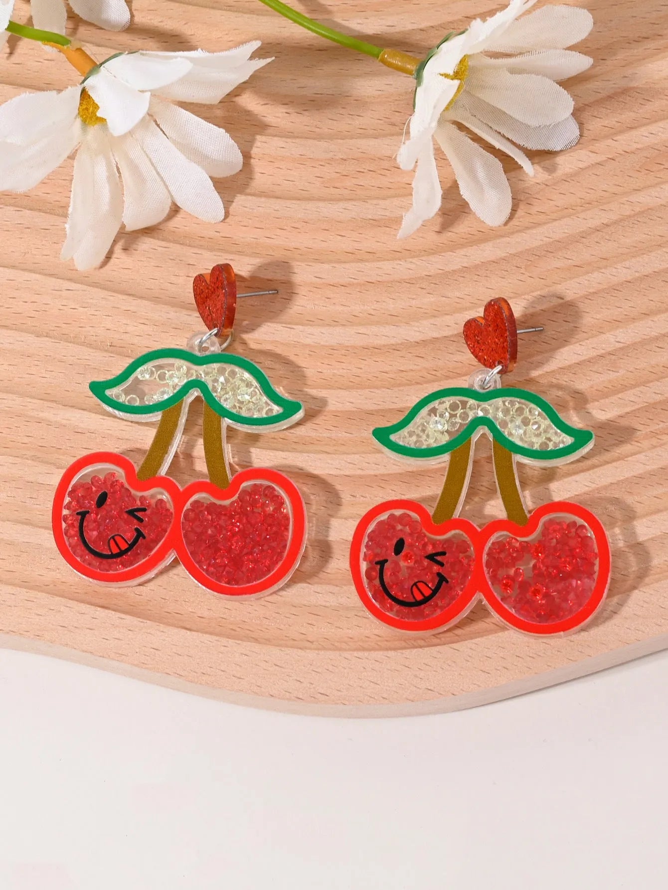Colourful acrylic novelty earrings shaped like fruits and desserts including cherry, strawberry, and ice cream.