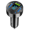 Black 4-port USB car charger with digital display plugged into a vehicle cigarette lighter socket.