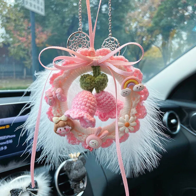 Handwoven wool bell orchid car pendant in green, hanging with dreamcatcher charm.