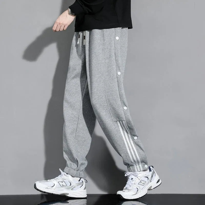 Men's black loose-fit sweatpants with ankle ties and a drawstring high waist on a neutral background.