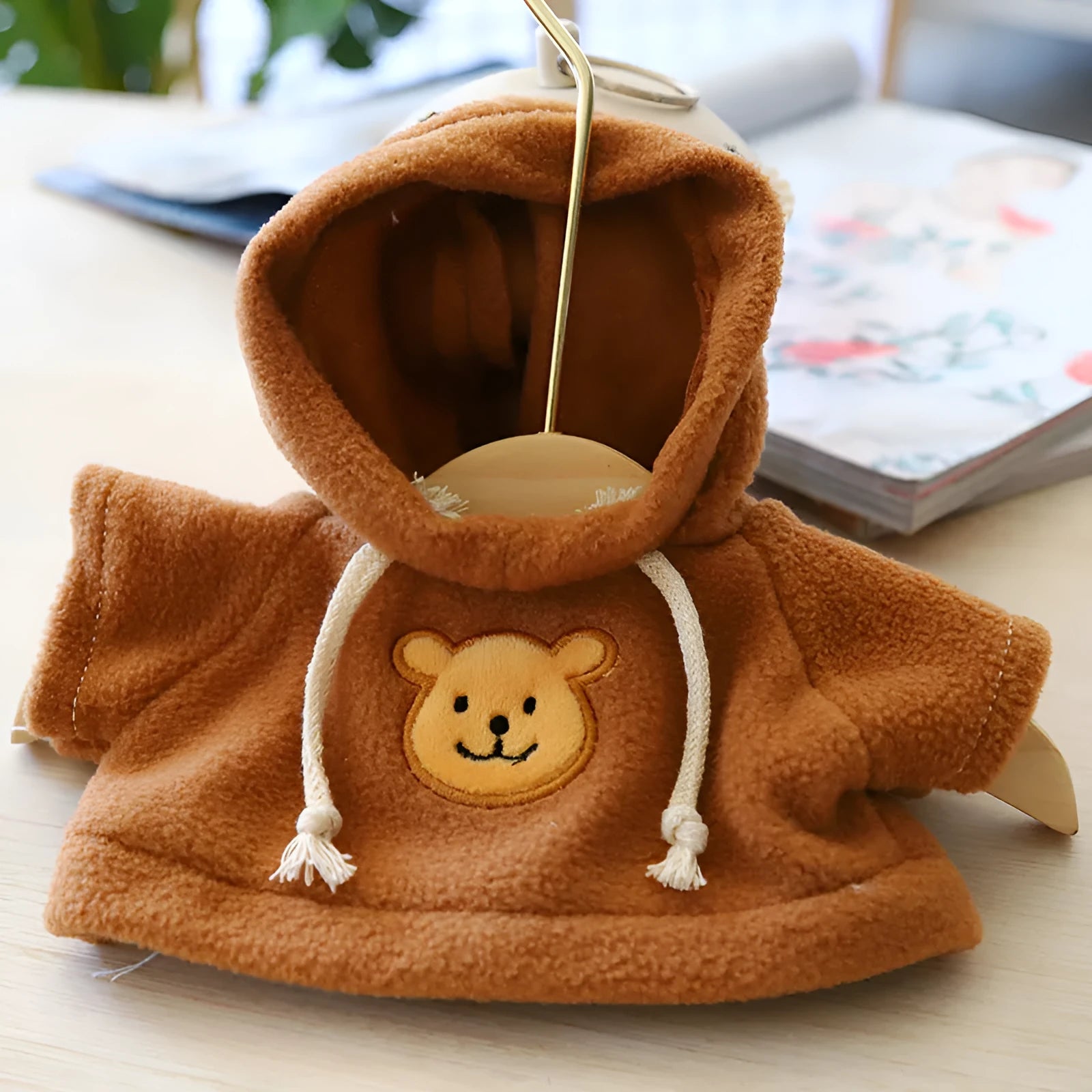 A selection of dog sweaters and hoodies in blue, pink, red, yellow, brown, and grey bear designs, shown in medium and large sizes.