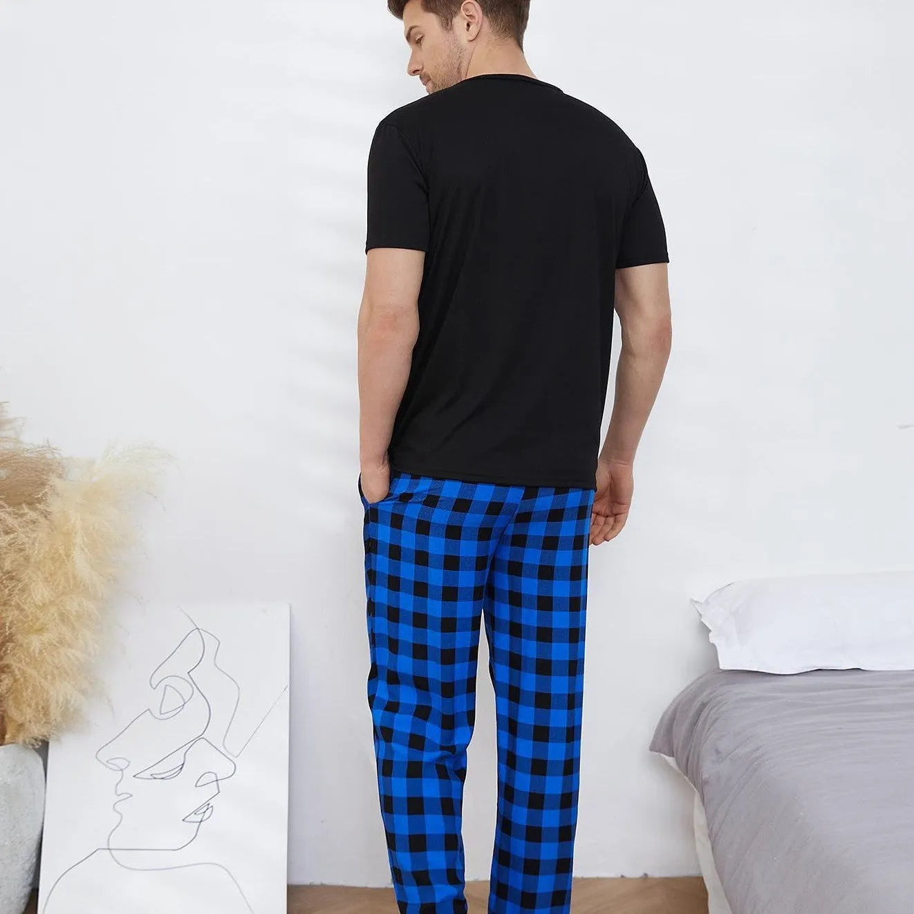 Men's black polyester short-sleeved pyjama set with long pants on a plain background
