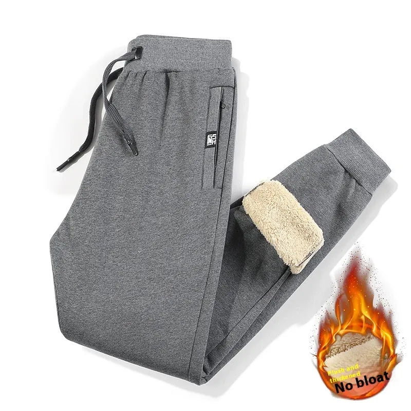 Man wearing grey fleece-lined oversized cotton track pants with a straight leg and mid-waist.