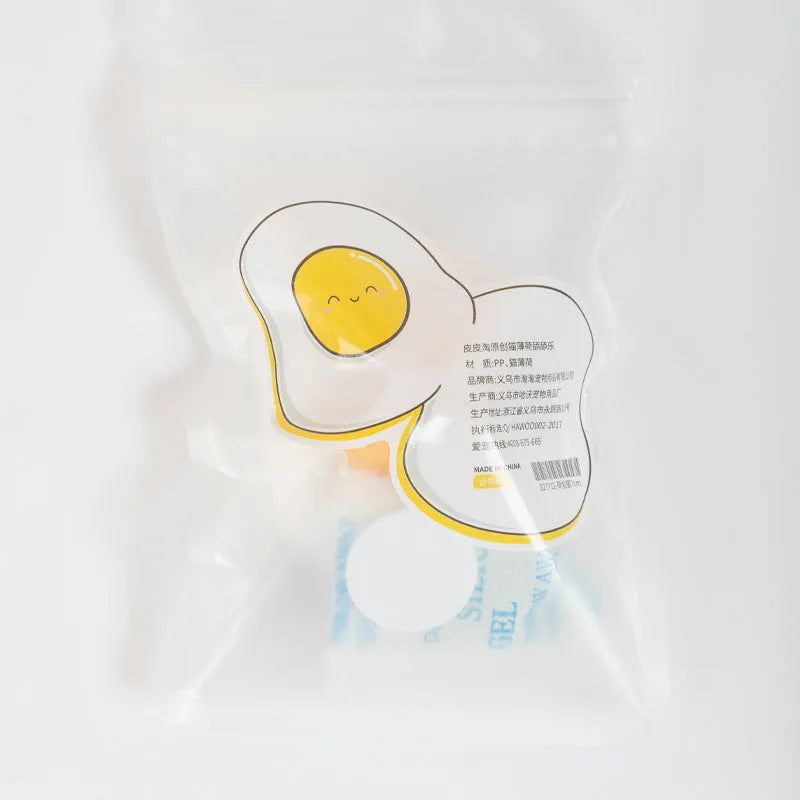 Soft plush catnip ball toy in fried egg shape stuck to a wall, with a cat playing.