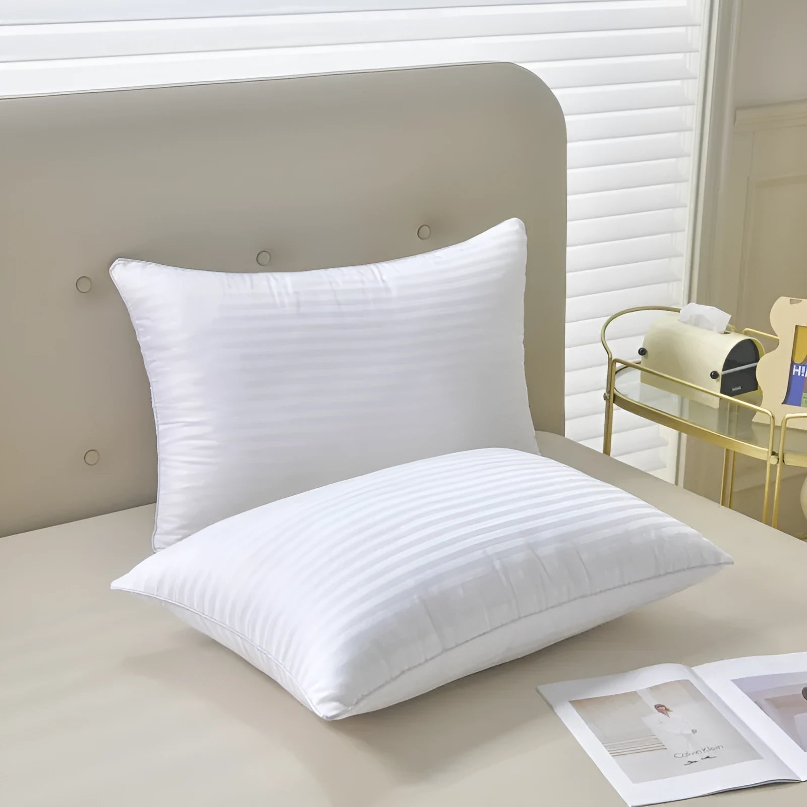 White cotton satin stripe pillow with feather and cotton filling on a bed.