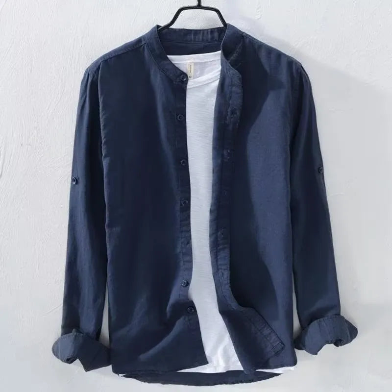 Man's loose fit long sleeve linen shirt in dark blue, showing button front and casual style.