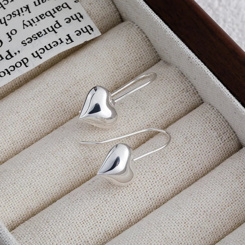 Silver-coloured heart-shaped earrings with three-dimensional glossy design and Korean style aesthetics