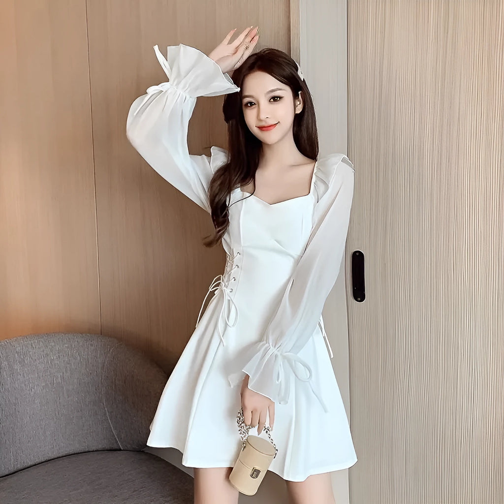 White chiffon patchwork dress with long sleeves and a waist-slimming silhouette on a woman