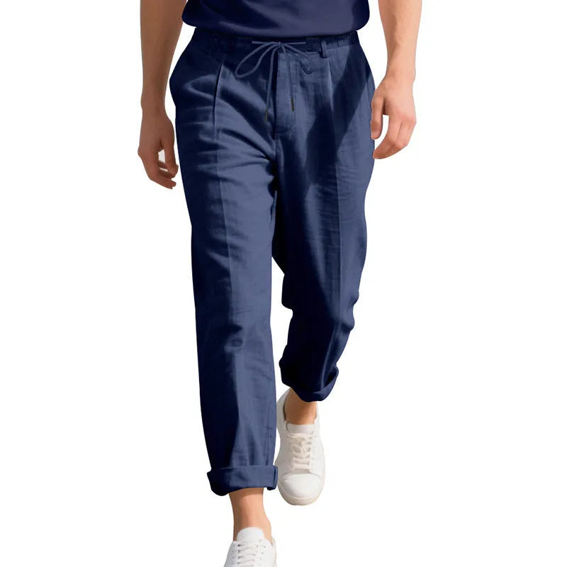 Men's light khaki linen casual trousers with a straight leg and drawstring waistband laid flat.