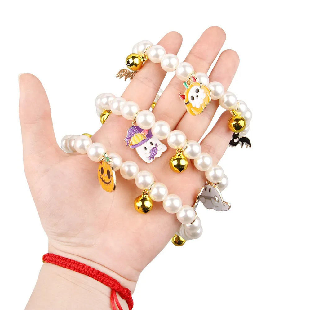Halloween cat collar with simulated pearls and pumpkin charms in purple ghost, skull, and smiling designs