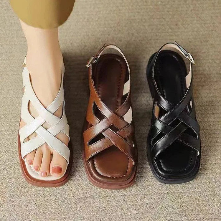 Women's glossy patent leather square toe sandals with cross strap on a brown background