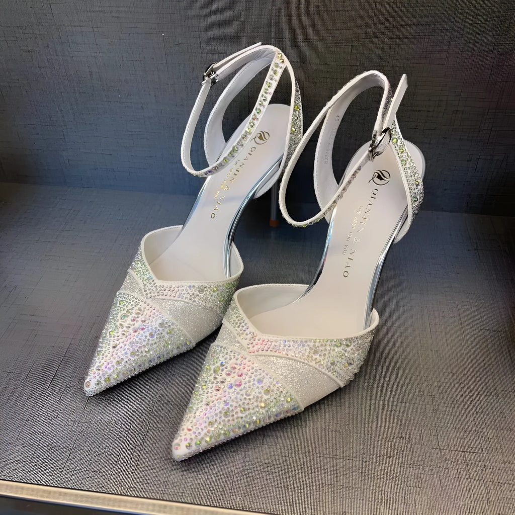 Women's silver high heel shoe with hollow stiletto heel, pointed toe, and bright red sole.