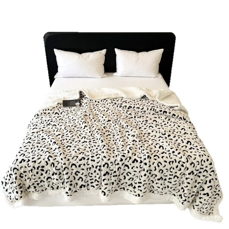 Double-layer leopard jacquard taffeta blanket in camel zebra pattern on a single bed.