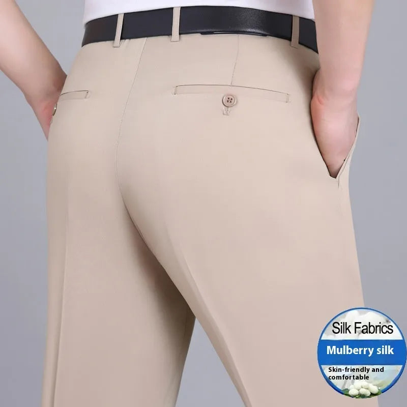 Man wearing dark blue straight-leg suit trousers with a high waist, made from a mulberry silk blend fabric.