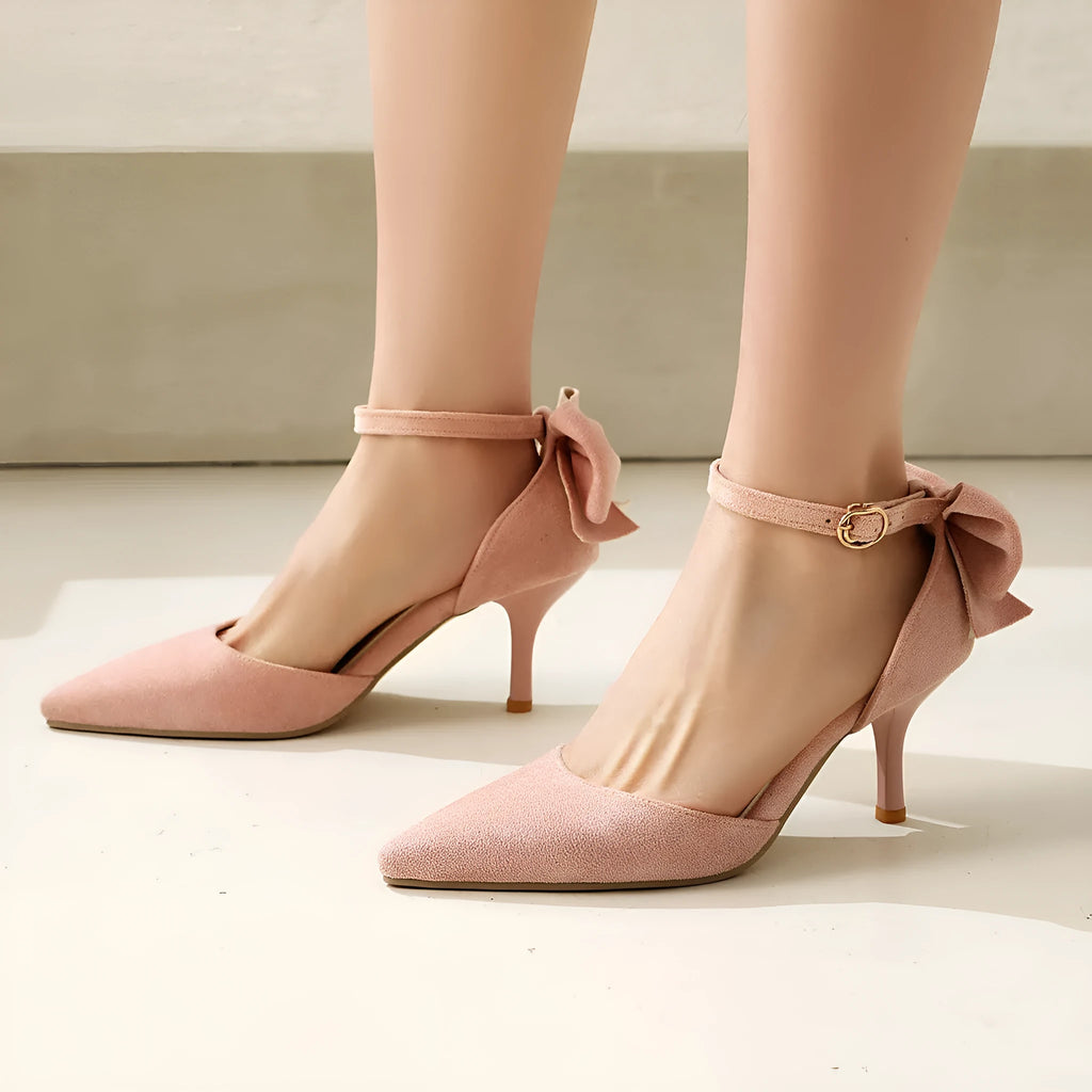 Women's black suede pointed-toe high heels with a stiletto heel and decorative bowknot at the ankle