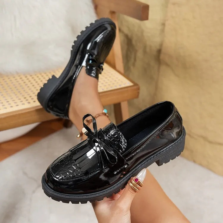 Women's black loafers with a bow detail on the front, made from artificial PU leather.
