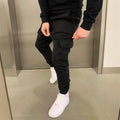 Man wearing loose light blue straight-leg casual trousers with patch pockets and an elasticated waistband.