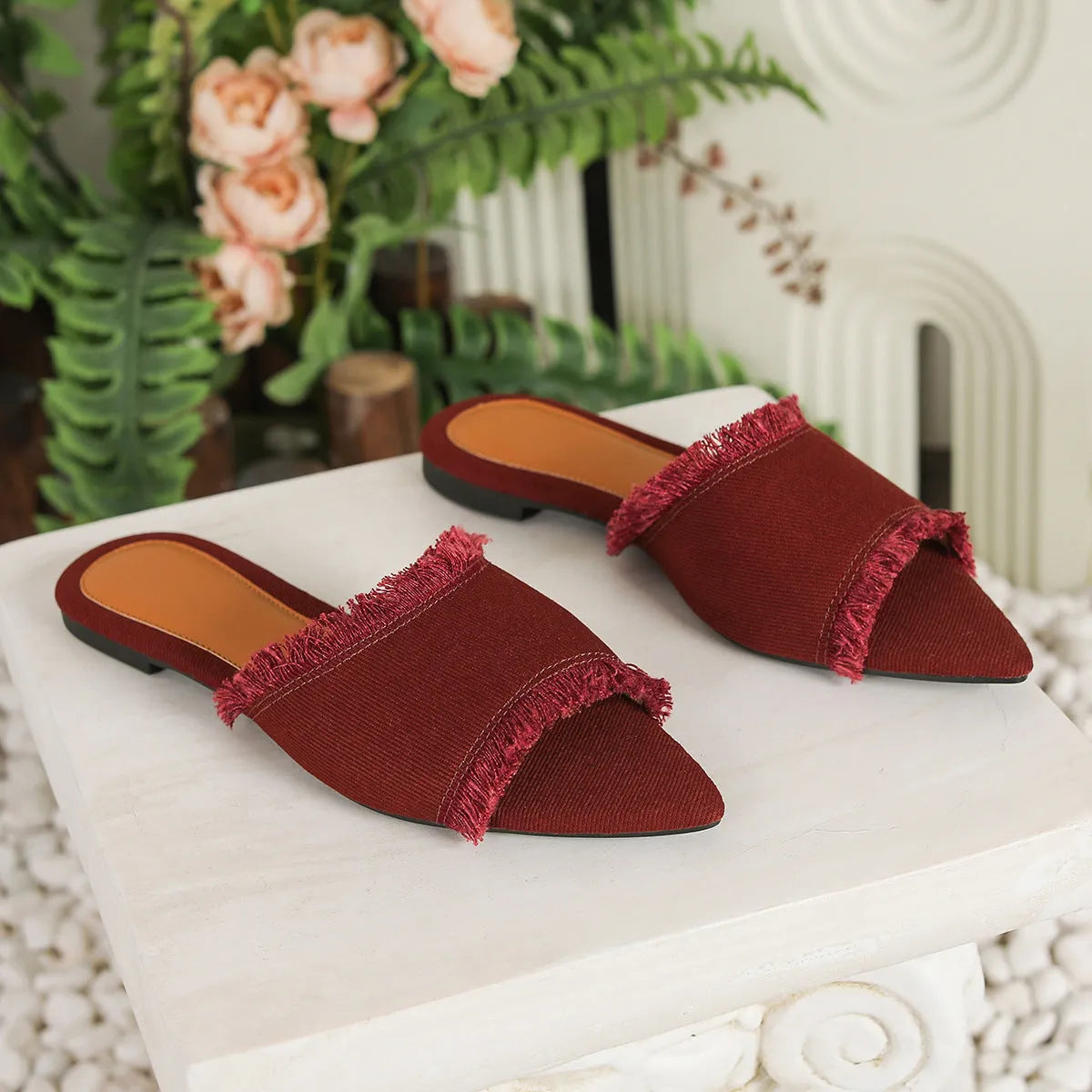 Women's denim flat slippers with a tassel, shown in available colours like apricot, black, and wine red.