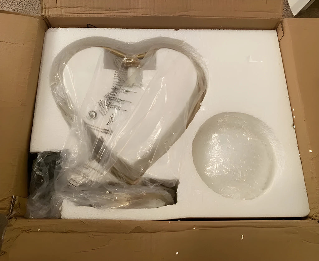 White plastic heart shaped night light with glowing centre on a wooden table
