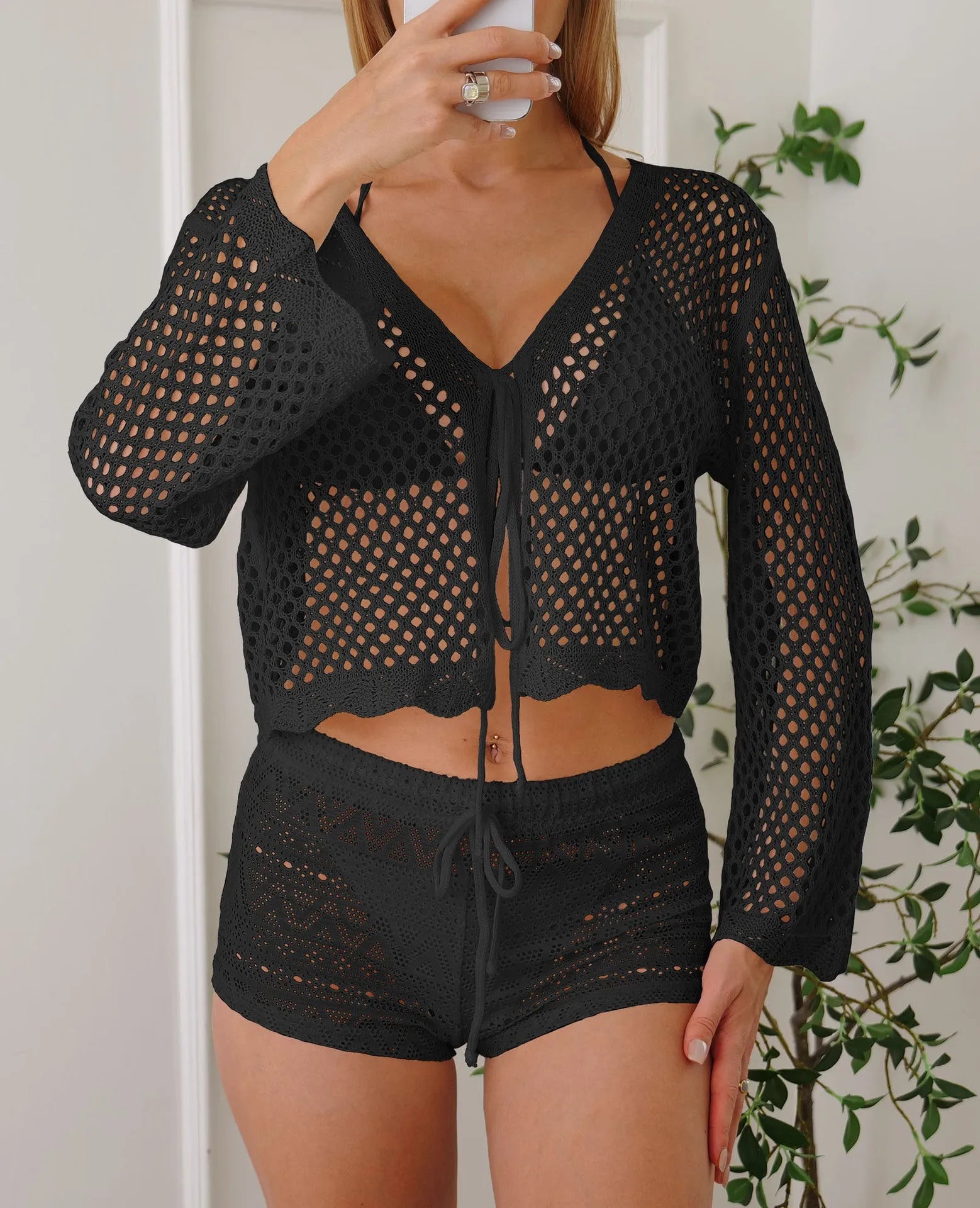 Women's short length cardigan blouse with nine-quarter bell sleeves in a hollow woven imitation cotton fabric.