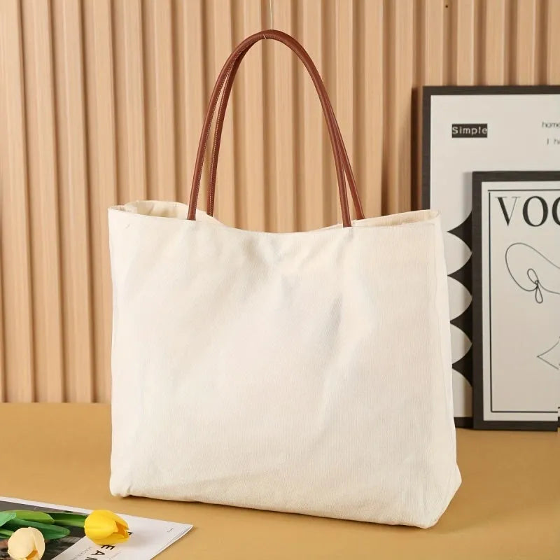 Heavyweight beige white canvas tote bag with reinforced handles on a plain background