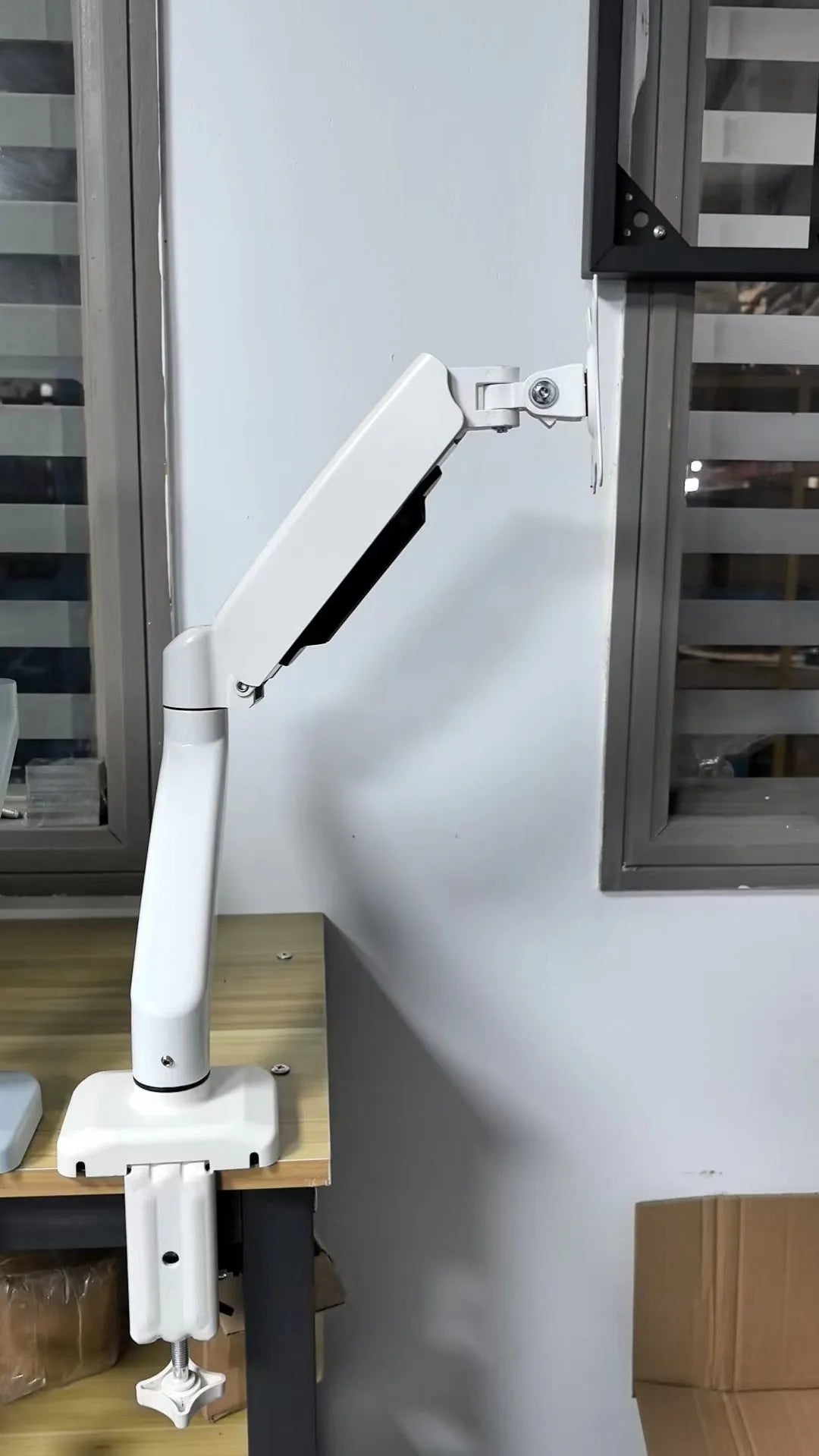 Black rotating telescopic LCD screen bracket on table with adjustable tilt and height