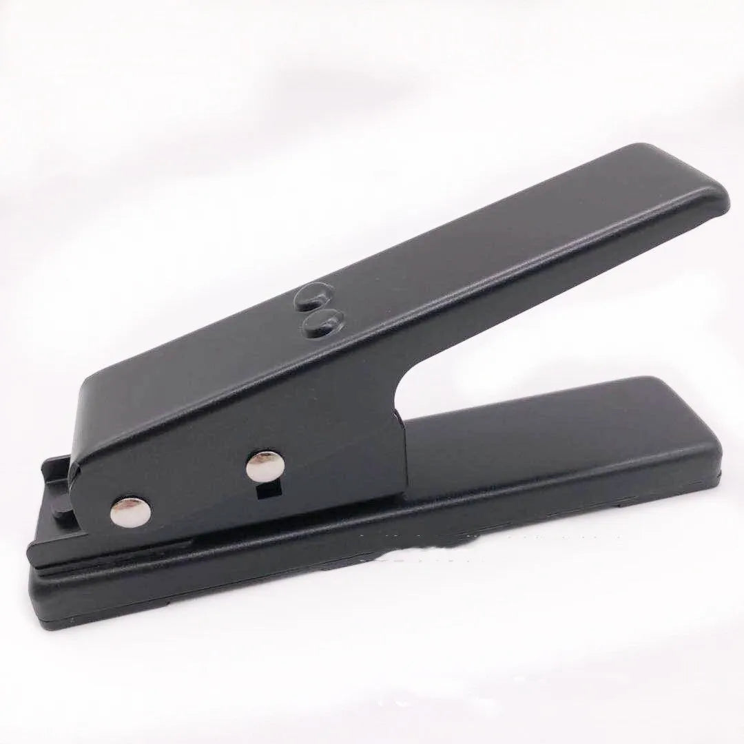 Gold metal guitar pick card cutter on a flat surface showing the punch head and metallic finish